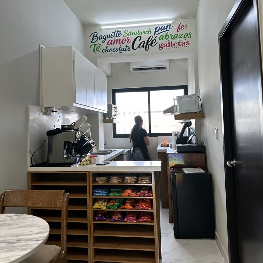 El mostrador con la cafetera y el exhibidor de galletas y botanas.