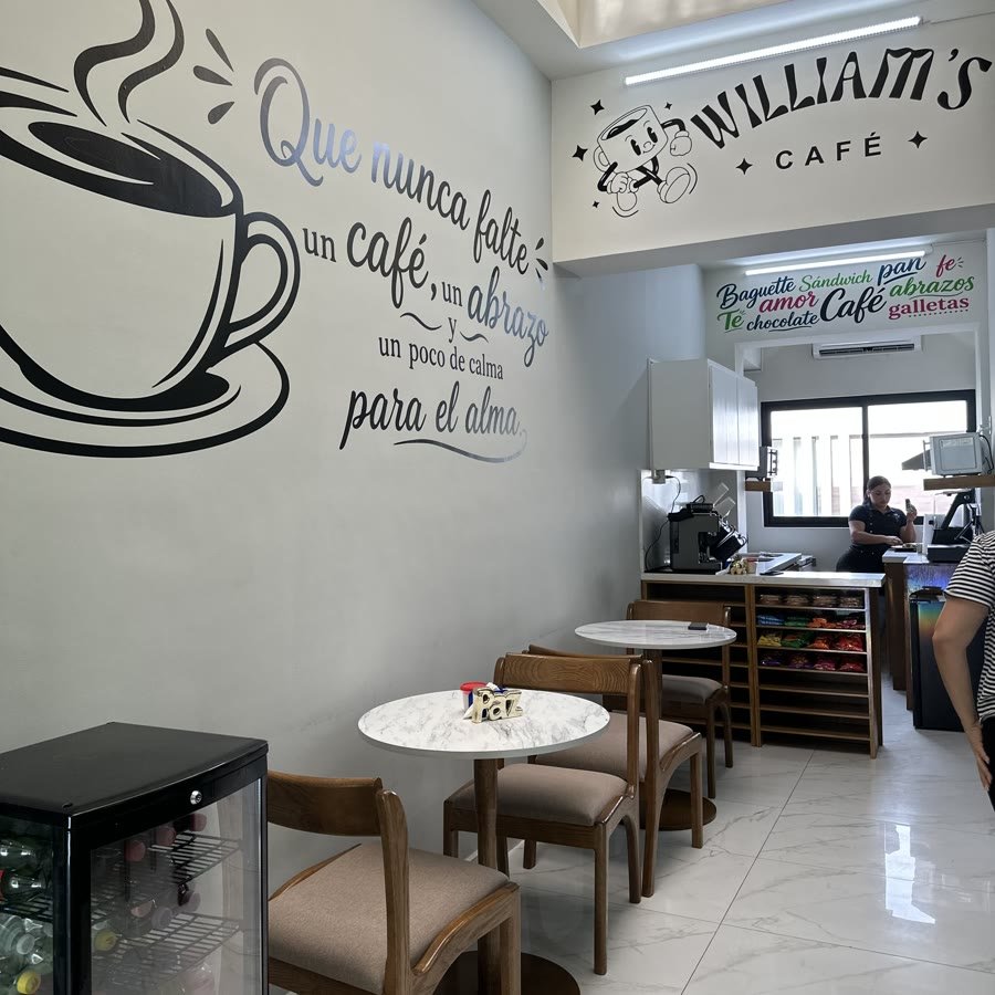 Las mesas de mármol y las sillas de madera bajo el mural de la taza.